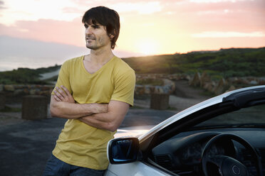 South Africa, smiling man at parked car at sunrise - TOYF000619