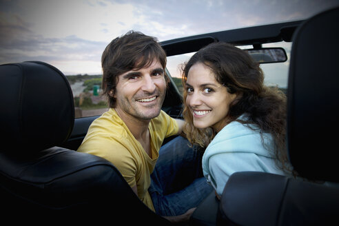 Südafrika, lächelndes Paar im Cabrio an der Küste bei Sonnenaufgang - TOYF000623