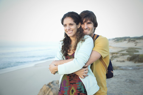 Südafrika, glückliches Paar in Umarmung am Strand, lizenzfreies Stockfoto