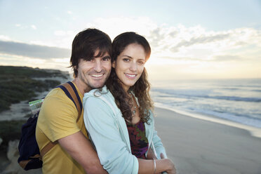 Südafrika, glückliches Paar, das sich bei Sonnenaufgang am Strand umarmt - TOYF000632