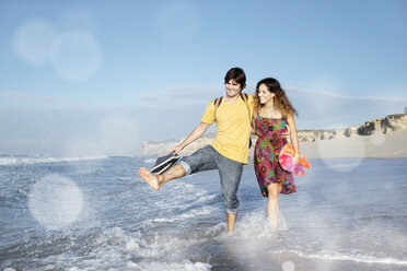 South Africa, happy couple wading in the ocean - TOYF000645