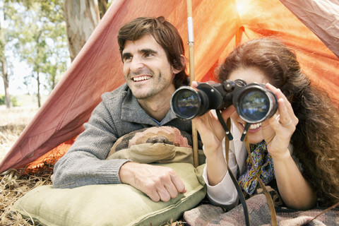Südafrika, glückliches Paar mit Fernglas im Zelt, lizenzfreies Stockfoto