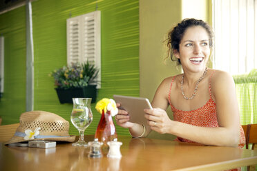 Glückliche Frau in einem Café mit digitalem Tablet - TOYF000680