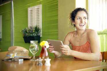 Happy woman in a cafe using digital tablet - TOYF000680