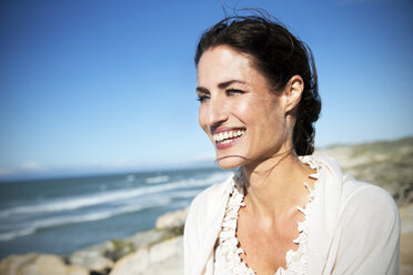 South Africa, portrait of smiling woman looking at the sea - TOYF000765