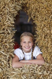 Deutschland, Lüneburger Heide, Porträt eines lächelnden blonden Mädchens mit Erntekrone - HRF000026