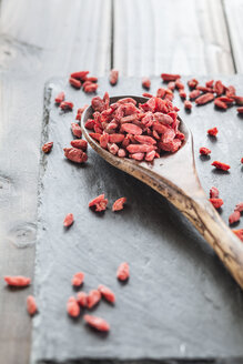 Holzlöffel mit Goji-Beeren auf einer Schiefertafel, Superfood - SBDF001889