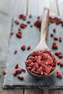 Holzlöffel mit Goji-Beeren auf einer Schiefertafel, Superfood - SBDF001890