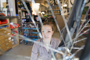 Junge Frau arbeitet in einer Fahrradwerkstatt - SGF001609