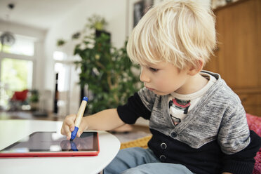 Little boy drawing with a digital pen on digital tablet at home - MFF001629