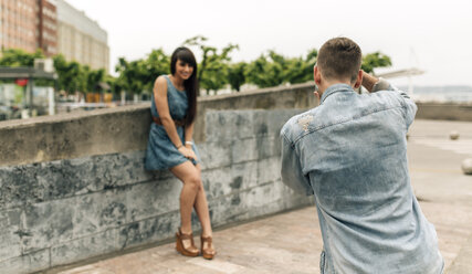 Spanien, Gijon, junger Mann fotografiert seine Freundin mit einer alten Kamera - MGOF000239