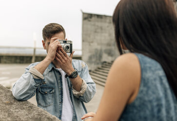 Spanien, Gijon, junger Mann fotografiert seine Freundin mit einer alten Kamera - MGOF000240