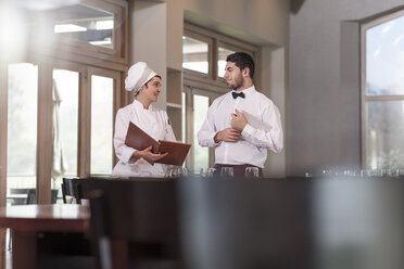 Koch und Kellner im Restaurant besprechen die Speisekarte - ZEF005131