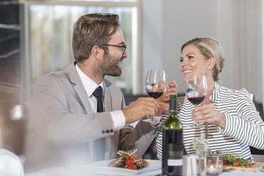 Mid adult couple in restaurant toasting with redwine - ZEF005161