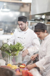 Zwei Frauen bereiten Essen in einer Restaurantküche vor - ZEF005184