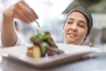 Young chef garnishing plate with food - ZEF005171