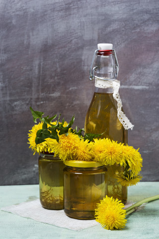 Löwenzahnsirup in der Flasche und Honig in Gläsern, lizenzfreies Stockfoto