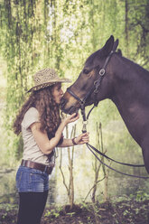 Young woman kissing Arabian horse - SARF001802