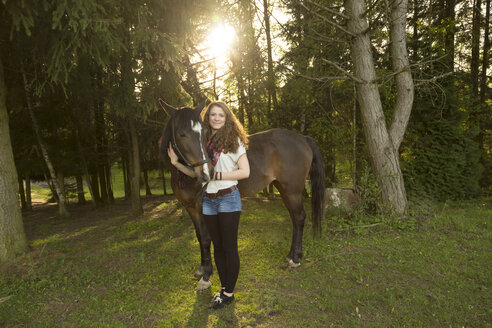Lächelnde junge Frau mit arabischem Pferd - SARF001803