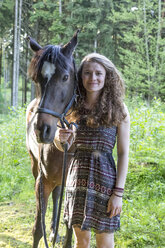 Smiling young woman with Arabian horse - SARF001805