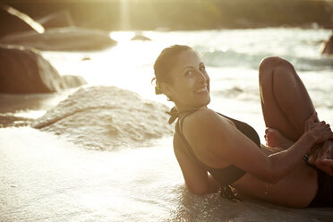 Seychellen, lächelnde Frau bei Yoga-Übung am Meer - ABF000611
