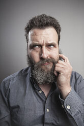 Portait of a mature man scratching his full beard - MMFF000790