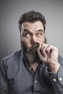 Portait of a mature man with full beard, picking his nose - MMFF000791