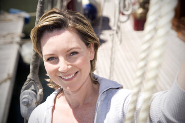 Portrait of a smiling mature woman on a sailing ship - TOYF000815