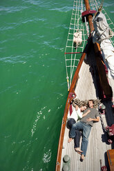 Entspanntes reifes Paar an Deck eines Segelschiffs liegend - TOYF000822