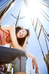 Laughing young woman on a sailing ship - TOYF000837