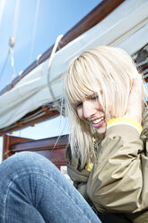 Lächelnde junge Frau auf einem Segelschiff - TOYF000893