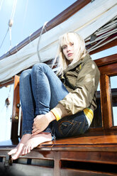 Young woman on a sailing ship sitting on a bench - TOYF000894