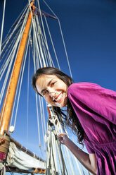 Lächelnde brünette junge Frau auf einem Segelschiff - TOYF000926