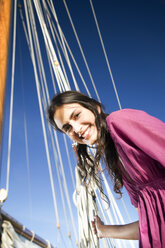 Lächelnde brünette junge Frau auf einem Segelschiff - TOYF000927
