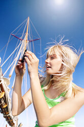 Young woman taking a cell phone picture on a sailing ship - TOYF001051