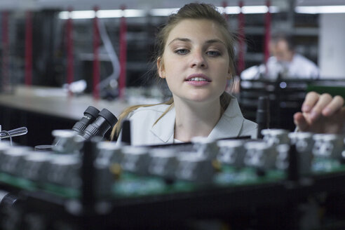 Technician working on circuit board - SGF001642