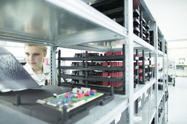 Technician at shelf with circuit boards - SGF001638