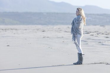 South Africa, Cape Town, young woman standing on the beach looking at distance - ZEF005237