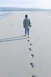 Südafrika, Kapstadt, Rückenansicht eines Jungen, der am Strand spazieren geht - ZEF005240