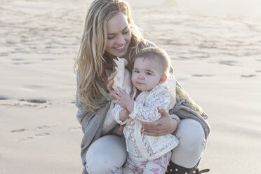 Mutter und kleines Mädchen mit Muschel am Strand - ZEF005257