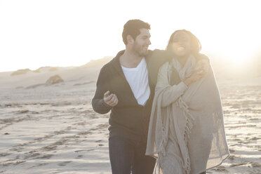 South Africa, Cape Town, young couple walking on the beach at sunset - ZEF005272