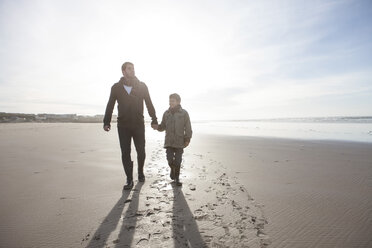 South Africa, Witsand, father and son walking on the beach at backlight - ZEF005294
