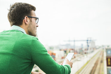 Man outdoors holding cell phone - UUF004441