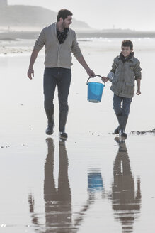 Südafrika, Witsand, Vater und Sohn tragen Eimer am Strand entlang - ZEF005308
