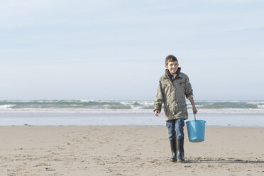 South Africa, Witsand, boy walking on the beach with blue bucket - ZEF005309