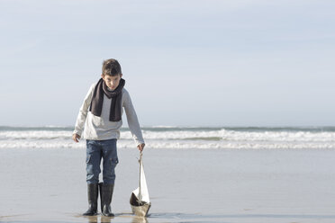 South Africa, Witsand, boy playing with toy sailing boat on the beach - ZEF005310