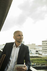 Confident businessman on bridge looking sideways - UUF004447