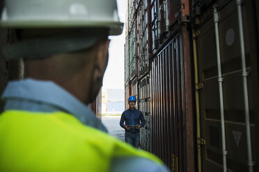 Zwei Männer mit Schutzhelmen im Containerhafen - UUF004463