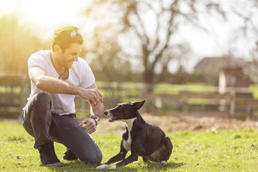 Man training his dog on a meadow - TAMF000179