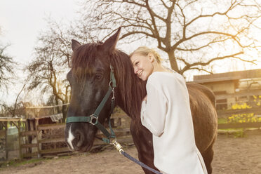 Frau mit Pferd auf einer Koppel - TAMF000184